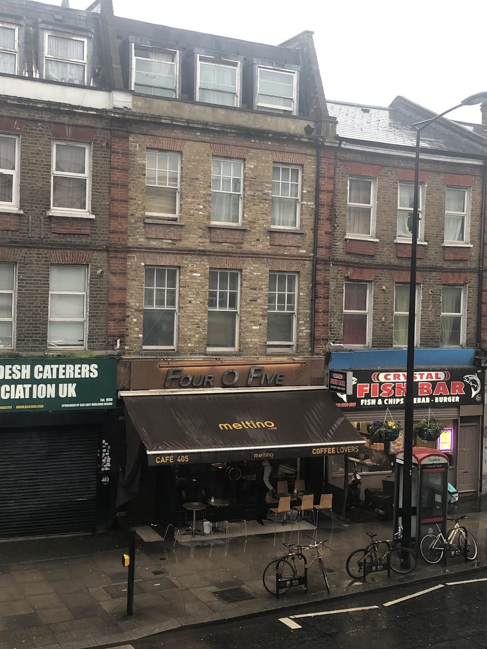 The Four O Five shopfront and awning on Harrow Road, seen from across the street with bikes parked outside